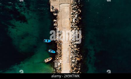Luftaufnahme des Wellenbrechers im Meer und kleiner Boote. Schöner abstrakter natürlicher Hintergrund. Stockfoto