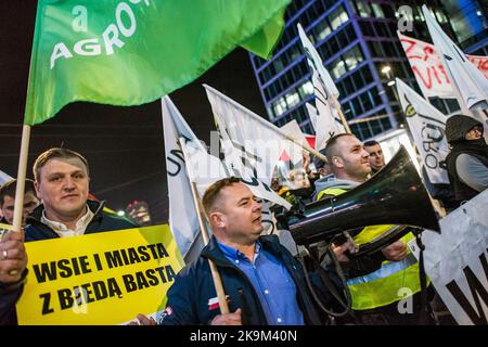 Warschau, Polen. 28. Oktober 2022. Demonstranten der Organisation Agro Union (Agro Unia) halten während des Krisenstreiks in Warschau Fahnen und ein Plakat. Hunderte von Demonstranten marschierten durch die Straßen Warschaus, um gegen die Politik der Regierung in Bezug auf hohe Energiepreise und die Abhängigkeit von fossilen Brennstoffen aus Russland, die Inflationskrise und die steigenden Gewinne der Energieunternehmen zu demonstrieren. Kredit: SOPA Images Limited/Alamy Live Nachrichten Stockfoto