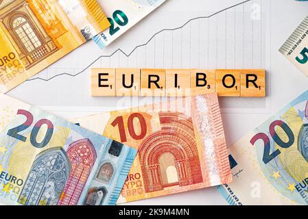 Wort EURIBOR ist in Holzbuchstaben auf dem Hintergrund von Euro Banknoten und Chart geschrieben. Kopieren Einfügen. Stockfoto