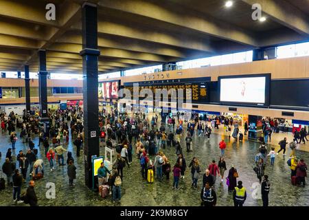 Menschenmenge, die vor der Abflugtafel steht und auf Bahnsteignummern wartet, Euston Station, London. Stockfoto