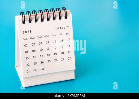 Januar 2023 weißer Tischkalender auf blauem Hintergrund. Stockfoto