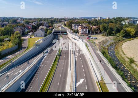 Neue Stadtautobahn Trasa Lagiewnicka in Krakau, Polen, mit Tunneln, Zufahrten, Radweg und Bürgersteig für Fußgänger. Regulierter Wilga-Fluss dekorieren Stockfoto