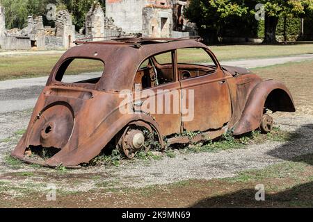 Die Überreste eines zerstörten Peugeot 202 Autos im Dorf Oradour-sur-Glane in der Haute-Vienne, Frankreich Stockfoto