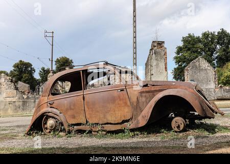 Die Überreste eines zerstörten Peugeot 202 Autos im Dorf Oradour-sur-Glane in der Haute-Vienne, Frankreich Stockfoto