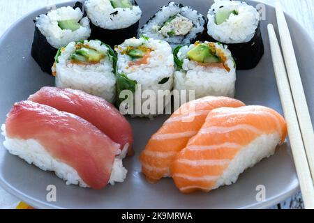 Platte von Sushi rollen. Sushi set Sashimi und Sushi Rollen auf holzteller serviert. Brötchen mit Lachs, Aal, Thunfisch, Avocado, Royal Garnelen, Frischkäse cavia Stockfoto