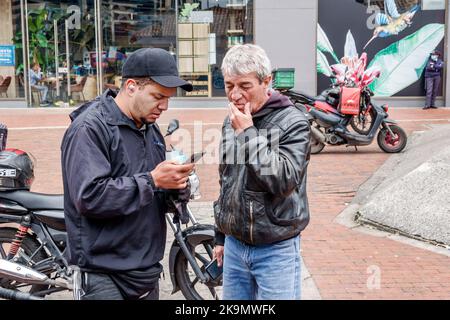 Bogota Kolumbien,Usaquen Avenida Carrera 7,Mann Männer Mann Vater Erwachsene Sohn Smartphone Smartphones Smartphone Handys Handy mit SMS lesen ch Stockfoto