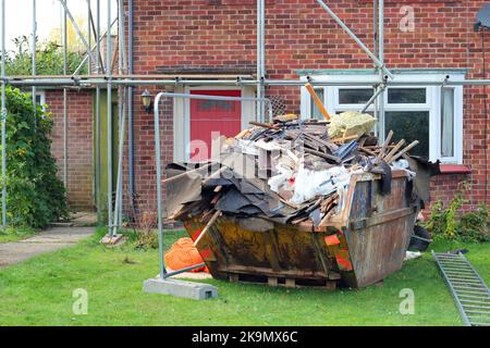 müllabfuhr vor einem Haus, das gerade renoviert wird. Überspringe voll ausgetauschter Innenausstattungen. Stockfoto