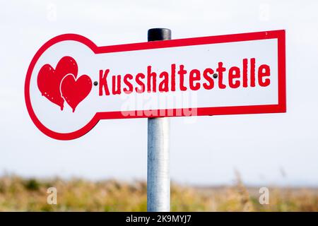 Wangerland, Deutschland. 29. Oktober 2022. Ein Schild mit der Aufschrift 'Kissing stop' steht in einem Feld neben einem Drahtgeflecht, das für sogenannte Liebesschlösser bestimmt ist. In der Nähe des Dorfes Bassens in der Gemeinde Wangerland können Liebhaber in diesem Rastplatz am Straßenrand für einen Kuss und gemeinsame Momente anhalten und sich mit einem von ihnen mitgebrachten Liebesschloss verewigen. Quelle: Hauke-Christian Dittrich/dpa/Alamy Live News Stockfoto