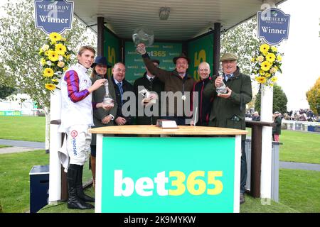 Der Jockey Harry Cobden (links) und Trainer Paul Nicholls (rechts) feiern mit der Trophäe, nachdem er die Charlie Hall Chase bet365 mit dem Pferd Bravemansgame am zweiten Tag des Charlie Hall Meetings bet365 auf der Wetherby Racecourse, West Yorkshire, gewonnen hat. Bilddatum: Samstag, 29. Oktober 2022. Stockfoto