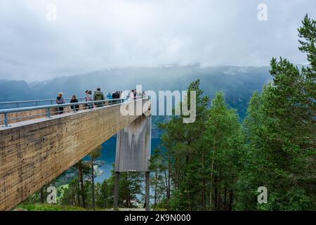 Aurland, Norwegen, 9. August 2022: Touristen bewundern die Landschaft von der beeindruckenden Holzplattform aus, um einen Blick über den Fjord von Aurland in Stegast zu genießen Stockfoto