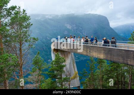 Aurland, Norwegen, 9. August 2022: Touristen bewundern die Landschaft von der beeindruckenden Holzplattform aus, um einen Blick über den Fjord von Aurland in Stegast zu genießen Stockfoto