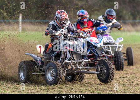 Purleigh Barns Farm, Latchingdon, Essex, Großbritannien. 29. Oktober 2022. Solo- und Seitenwagen-Motorräder sowie Quad-Bikes fuhren in verschiedenen Klassen auf einem Feld in der Nähe von Maldon in Essex um eine schlammige ovale Rennstrecke, organisiert vom Southend & District Motorcycle Club. Grasstrack-Rennen ist ähnlich wie Speedway-Rennen. Die Wettkampfklassen variieren zwischen im Uhrzeigersinn und gegen den Uhrzeigersinn. Die Motorleistung reicht bis zu 1000cc und umfasst Vintage-Maschinen vor 1975. 7 - John Elliott in der Quads-Klasse Stockfoto