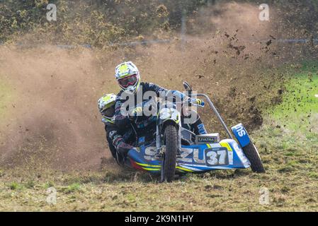 Purleigh Barns Farm, Latchingdon, Essex, Großbritannien. 29. Oktober 2022. Solo- und Seitenwagen-Motorräder sowie Quad-Bikes fuhren in verschiedenen Klassen auf einem Feld in der Nähe von Maldon in Essex um eine schlammige ovale Rennstrecke, organisiert vom Southend & District Motorcycle Club. Grasstrack-Rennen ist ähnlich wie Speedway-Rennen. Die Wettkampfklassen variieren zwischen im Uhrzeigersinn und gegen den Uhrzeigersinn. Die Motorleistung reicht bis zu 1000cc und umfasst Vintage-Maschinen vor 1975. 37 - Mark Cossar und Gareth Williams in der rechten Seitenwagenklasse Stockfoto