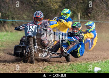 Purleigh Barns Farm, Latchingdon, Essex, Großbritannien. 29. Oktober 2022. Solo- und Seitenwagen-Motorräder sowie Quad-Bikes fuhren in verschiedenen Klassen auf einem Feld in der Nähe von Maldon in Essex um eine schlammige ovale Rennstrecke, organisiert vom Southend & District Motorcycle Club. Grasstrack-Rennen ist ähnlich wie Speedway-Rennen. Die Wettkampfklassen variieren zwischen im Uhrzeigersinn und gegen den Uhrzeigersinn. Die Motorleistung reicht bis zu 1000cc und umfasst Vintage-Maschinen vor 1975. 124 - Danny Hill und Harry Hill in der linken Seitenwagenklasse Stockfoto