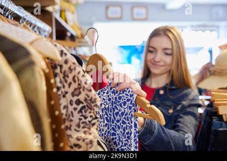 Junge Frau Kauft Gebrauchte Nachhaltige Kleidung Aus Dem Second Hand Charity Shop Stockfoto