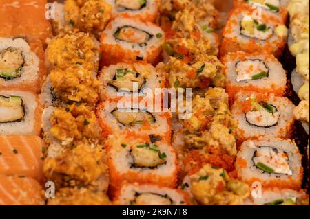 Eine Reihe verschiedener Rollentypen in einer Schachtel. Blick von oben auf verschiedene Portionen vegetarischer und Fischbrötchen. Nahaufnahme, selektiver Fokus. Stockfoto