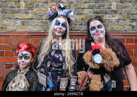 London, Großbritannien. 29. Oktober 2022. Die Teilnehmer haben viel Spaß beim Posen bei der Prozession. Die Columbia Road feiert die mexikanische Tradition mit dem Londoner Day of the Dead Festival mit Kostümen, Künstlern, einer Parade, dekorierten Geschäften und Ständen. Kredit: Imageplotter/Alamy Live Nachrichten Stockfoto