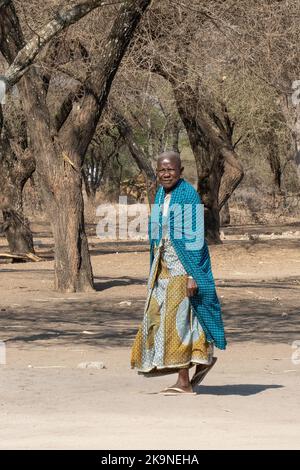 Tarangire, Tansania - 12.. Oktober 2022: Eine ältere masai-Frau, die an einem sonnigen Tag in der Savanne spazieren geht. Stockfoto