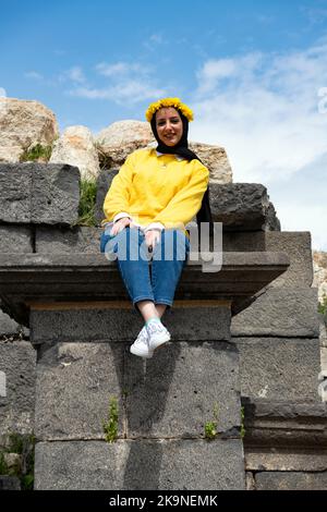 Das hübsche Mädchen aus Jordanien trägt den gelben Caeser Lorbeerkranz Umm Qais (Gadara) Jordan Stockfoto