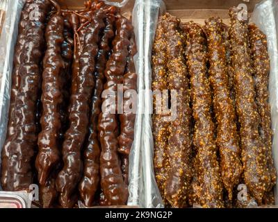 Georgische Süßigkeiten. Nüsse in gefrorenen Traubensaft auf der Theke. churchkhela auf dem Markt. Süße Speisen im Sortiment. Geschäft in Georgien. East Market. Traube Stockfoto