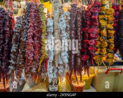 Georgische Süßigkeiten. Nüsse in gefrorenem Traubensaft auf der Theke. Pflaume churchkhela auf dem Markt. Süße Speisen im Sortiment. Geschäft in Georgien. East Market. G Stockfoto