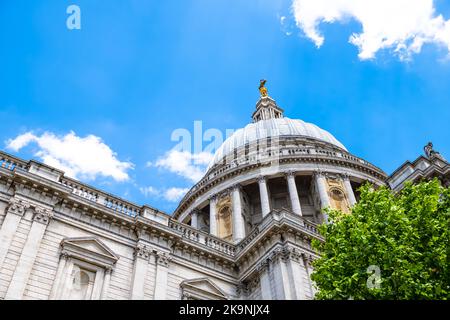 Blick auf die Kuppel der St. Paul's Cathedral Kirche mit Kreuz im Sommer und grünem Laub in der City of London, Großbritannien Stockfoto