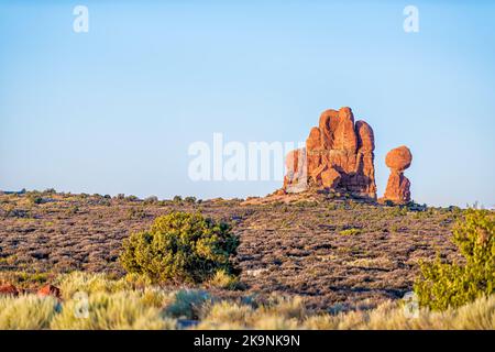 Ausgewogener Felsen im Utah Arches National Park butte weit entfernte Sicht am Horizont bei Sonnenaufgang mit orangefarbener Farbe Stockfoto