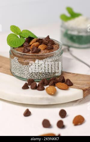 chia Pudding mit Schokolade und Mandeln auf weißem Tisch Stockfoto