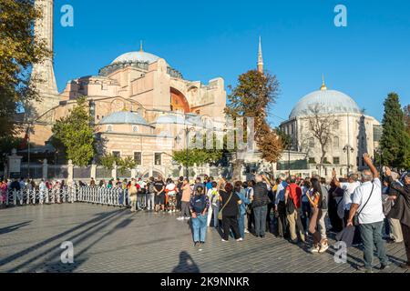 Touristen stehen in der Schlange, um die Hagia Sofia Kathedrale zu betreten. Fatih, Istanbul, Türkei. Lange Schlange, um das Wahrzeichen von Istanbul zu besuchen - Sofia Kirche/Moschee. Stockfoto