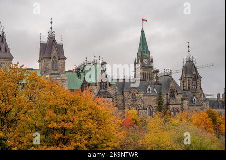 Die Türme des East Blocks auf dem kanadischen Parlamentshügel, die sich in der Ferne über den Bäumen des Rideau-Kanals erheben. Stockfoto