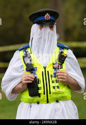 Manchester, Großbritannien. 29. Oktober 2022. Polizeibeamter beim Weltrekordversuch als Anzahl von Menschen, die im Platt Fields Park in Manchester als Gespenster gekleidet waren. Der von Paranormal Rescue initiierte Versuch brachte Geld für die Hunde-Wohltätigkeitsorganisation Greyhound Gap ein. Der Versuch blieb hinter dem Weltrekord zurück, den die Organisatoren wegen des schlechten Wetters und der kürzlichen Stiche in der Nähe von Studentenunterkünften im Owens Park Studentenunterkünften in Fallowfield verantwortlich machten. Kredit: GaryRobertsphotography/Alamy Live Nachrichten Stockfoto