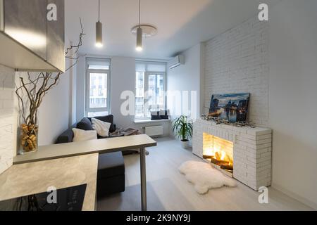 Komfortables Studio-Apartment-Design. Inneneinrichtung des Hotelzimmers mit Schlafbereich, Wohnbereich und Kochnische. Apartment- und Interieurkonzept Stockfoto