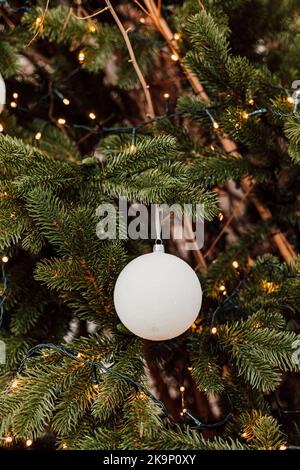 Eine weiße Weihnachtskugel auf dem Baum. Silvester Stockfoto