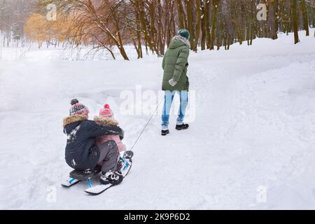Vater mit Kindern haben Spaß im Winter im Freien. Familienkonzept Stockfoto