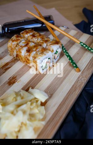 Sushi-Set mit verschiedenen Arten von Brötchen und Sashimi aus Aal, Lachs, Thunfisch, Garnelen, rotem Kaviar und fliegendem Fischrogen aus Tobiko. Pan-asiatische und asiatische Fo Stockfoto