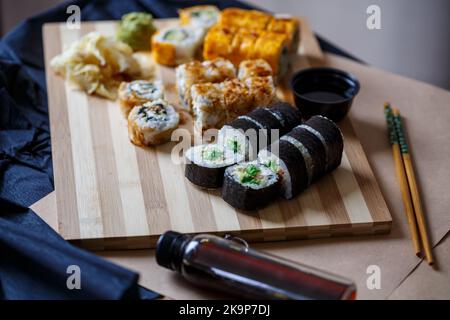 Sushi-Set mit verschiedenen Arten von Brötchen und Sashimi aus Aal, Lachs, Thunfisch, Garnelen, rotem Kaviar und fliegendem Fischrogen aus Tobiko. Pan-asiatische und asiatische Fo Stockfoto