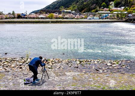 Kyoto, Japan - 11. April 2019: Professioneller Fotograf, der im Frühjahr die Brücke von Togetsu-kyo am Fluss Katsura am Arashiyama Park fotografiert Stockfoto