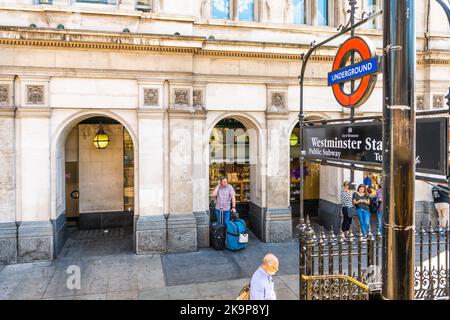 London, Großbritannien - 22. Juni 2018: Westminster U-Bahn-Station U-Bahn-Schild mit Leuten, die im Sommer in den Eingang gehen Stockfoto