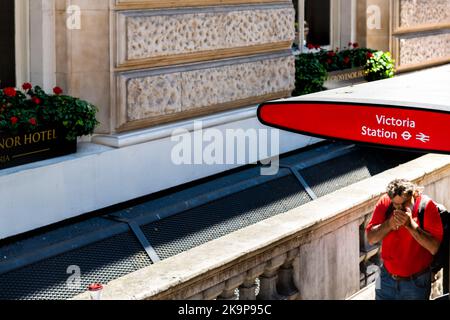 London, Vereinigtes Königreich - 22. Juni 2018: Bushaltestelle Victoria Station, Schild mit öffentlichen Verkehrsmitteln für Reisebusse, an denen Leute vorbei gehen Stockfoto