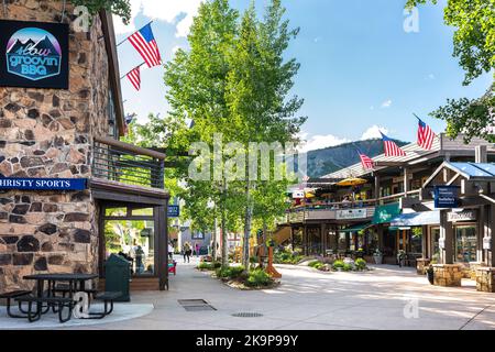 Aspen, USA - 24. Juni 2019: Snowmass Village Town City mit Strip Shopping Mall in Colorado Downtown mit Sportgeschäft und Sotheby's Immobilien Stockfoto
