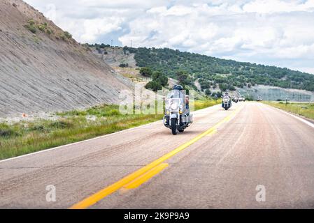 Lonetree, USA - 24. Juli 2019: Karge, trockene Canyon-Landschaft in der Wyoming Highway 414 Road mit Bikern auf Harley Davidson Motorrädern Stockfoto