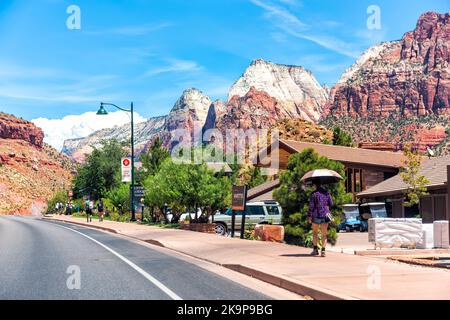 Springdale, USA - 5. August 2019: Mountain Canyon Stadt am Zion Nationalpark mit Menschen, die im Sommer auf der Hauptstraße auf dem Bürgersteig spazieren gehen Stockfoto