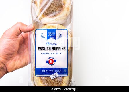 Naples, USA - 21. Oktober 2021: Closeup Macro Hand Holding Lebensmittelhändler Joe's Private Label von englischen Muffins Brötchen klassische Frühstück Brot Stockfoto