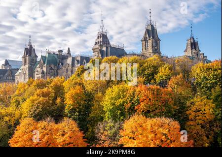 Die Türme des East Blocks auf dem kanadischen Parlamentshügel, die sich in der Ferne über den Bäumen des Rideau-Kanals erheben. Stockfoto