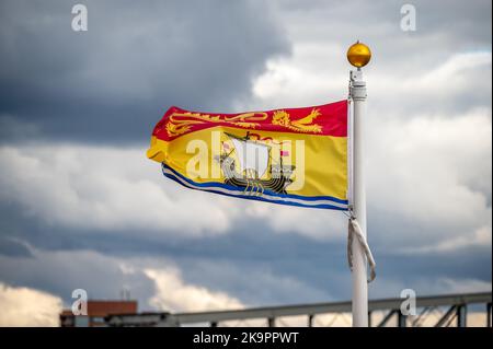 Die Flagge von New Brunswick verzichtet an einem bewölkten kanadischen Tag. Stockfoto