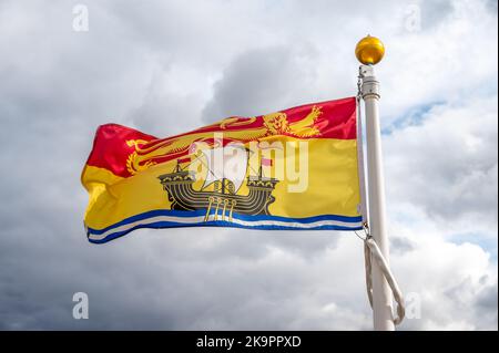 Die Flagge von New Brunswick verzichtet an einem bewölkten kanadischen Tag. Stockfoto