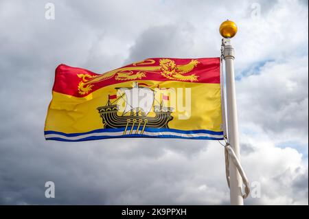 Die Flagge von New Brunswick verzichtet an einem bewölkten kanadischen Tag. Stockfoto