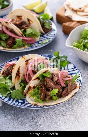 Rindfleisch-Tacos mit Salat und eingelegten roten Zwiebeln Stockfoto