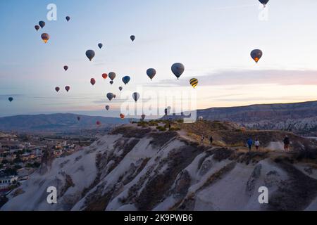 Atemberaubender Sonnenuntergang aus der Vogelperspektive mit zahlreichen farbenfrohen Heißluftballons, die über Kappadokien fliegen. Türkische Touristenattraktionen. Hochwertige Fotos Stockfoto