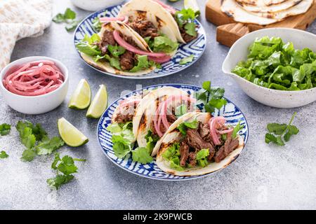 Rindfleisch-Tacos mit Salat und eingelegten roten Zwiebeln Stockfoto